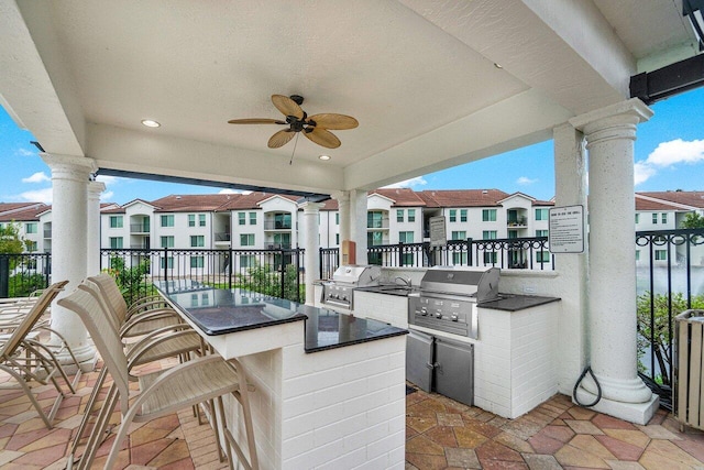 view of patio / terrace with ceiling fan, area for grilling, and exterior bar