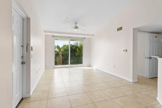 tiled spare room with ceiling fan