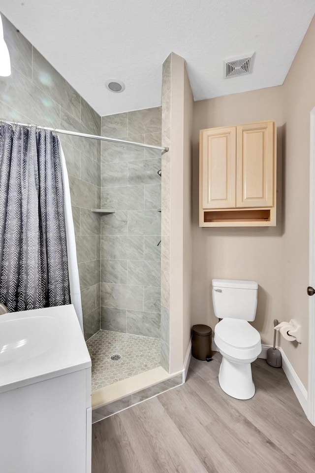 bathroom with a shower with curtain, vanity, toilet, and hardwood / wood-style floors