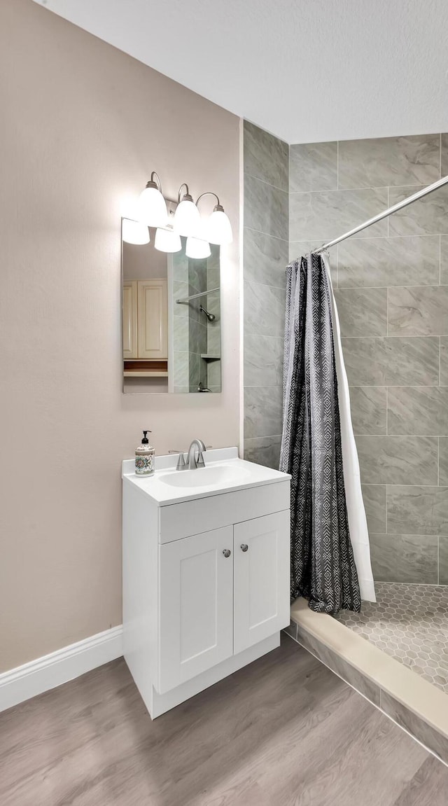 bathroom featuring wood-type flooring, vanity, and walk in shower