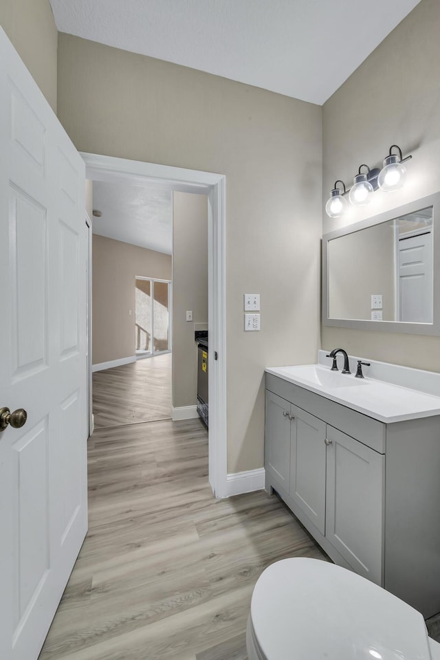 bathroom with vanity, toilet, and wood-type flooring