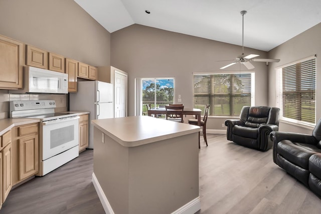 kitchen featuring a center island, white appliances, vaulted ceiling, ceiling fan, and light wood-type flooring