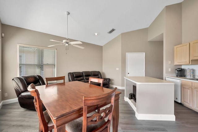 dining space with ceiling fan, dark wood-type flooring, and vaulted ceiling