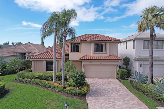 mediterranean / spanish house featuring a front yard and a garage