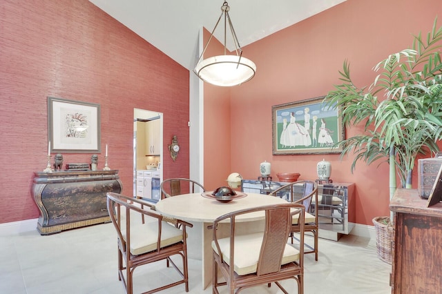 dining area featuring high vaulted ceiling