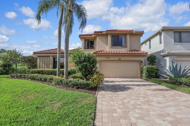 mediterranean / spanish home featuring a garage and a front lawn