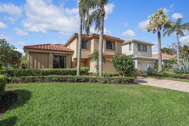 mediterranean / spanish house with a garage and a front lawn