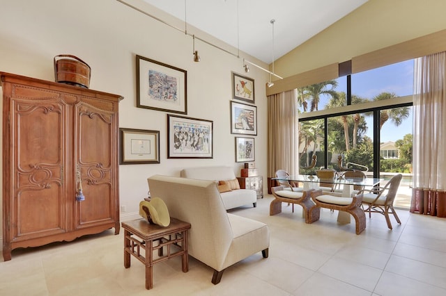 sitting room featuring light tile patterned floors and high vaulted ceiling