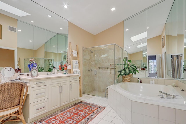 bathroom with tile patterned flooring, shower with separate bathtub, vanity, and vaulted ceiling with skylight