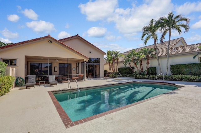 view of swimming pool featuring ceiling fan and a patio