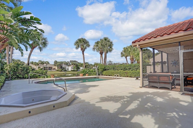 view of swimming pool with a sunroom, a jacuzzi, and a patio