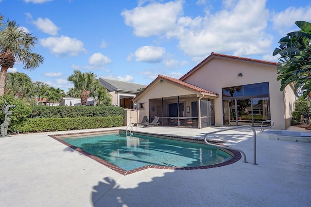 view of swimming pool with a sunroom and a patio