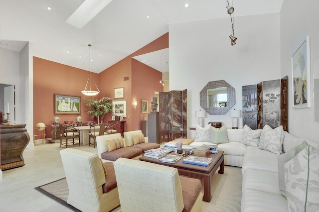 living room with a skylight and high vaulted ceiling