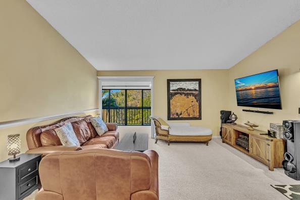 carpeted living room featuring lofted ceiling