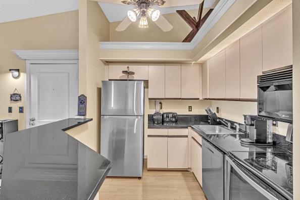 kitchen with ceiling fan, sink, light hardwood / wood-style flooring, cream cabinets, and appliances with stainless steel finishes