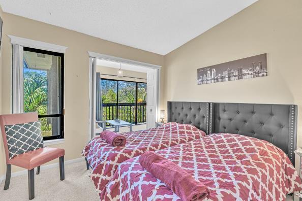 bedroom with access to exterior, carpet, multiple windows, and lofted ceiling