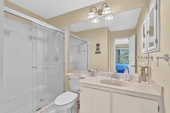 bathroom with vanity, toilet, and a shower with shower door