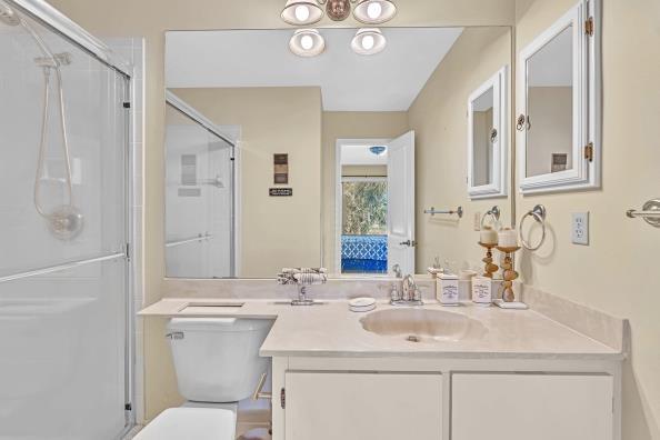 bathroom featuring vanity, toilet, and a shower with shower door