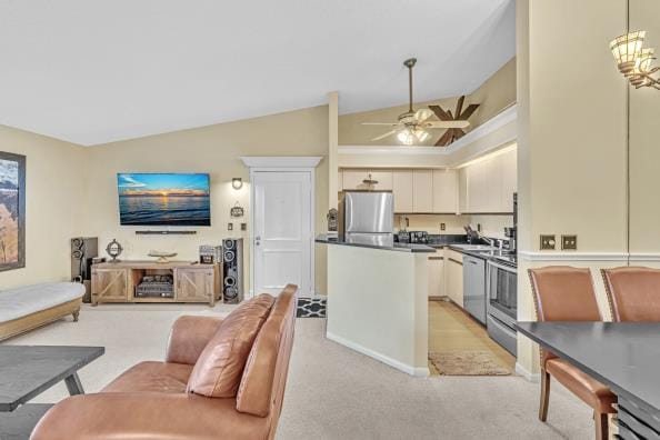 kitchen featuring stainless steel fridge, vaulted ceiling, ceiling fan, dishwasher, and hanging light fixtures