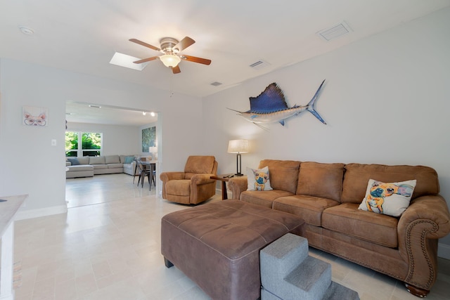 living room featuring a skylight and ceiling fan