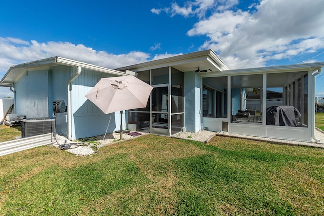 rear view of property featuring a sunroom, cooling unit, and a lawn