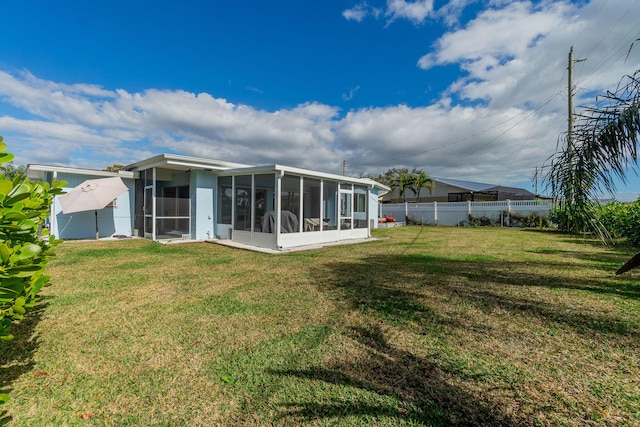 back of house featuring a yard and a sunroom