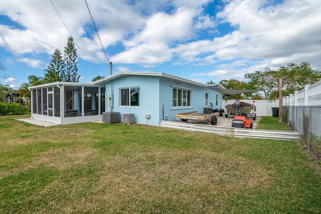 back of house featuring a sunroom, a yard, and central air condition unit