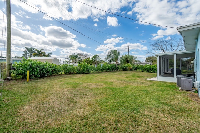 view of yard with a sunroom and central AC unit