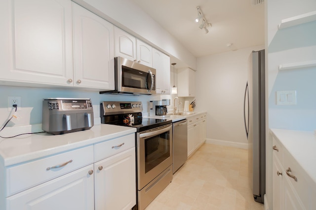 kitchen featuring track lighting, appliances with stainless steel finishes, sink, and white cabinets