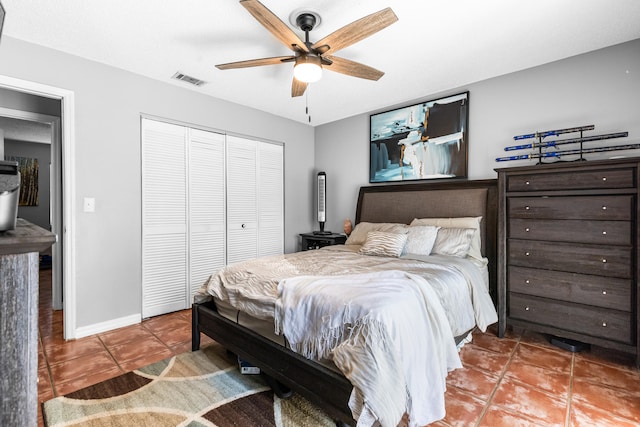 tiled bedroom featuring ceiling fan and a closet