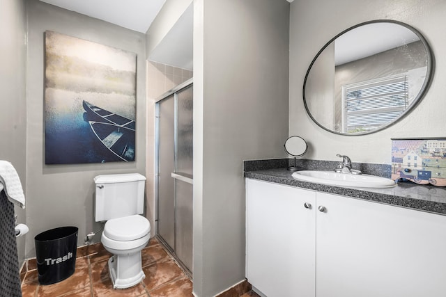 bathroom with vanity, toilet, and a shower with shower door