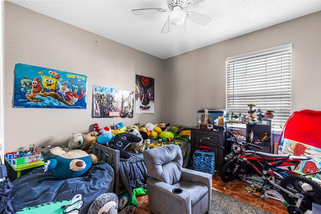 bedroom featuring tile patterned floors, ceiling fan, and a textured ceiling