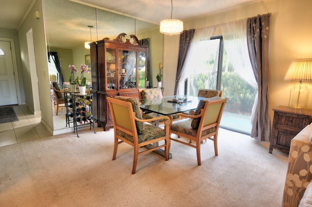 dining room with ornamental molding and light carpet