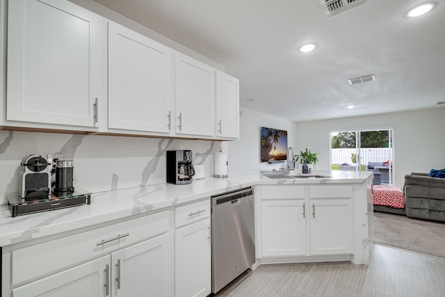 kitchen featuring white cabinetry, dishwasher, sink, kitchen peninsula, and light stone countertops