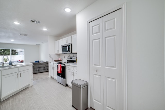 kitchen featuring white cabinetry, appliances with stainless steel finishes, and sink