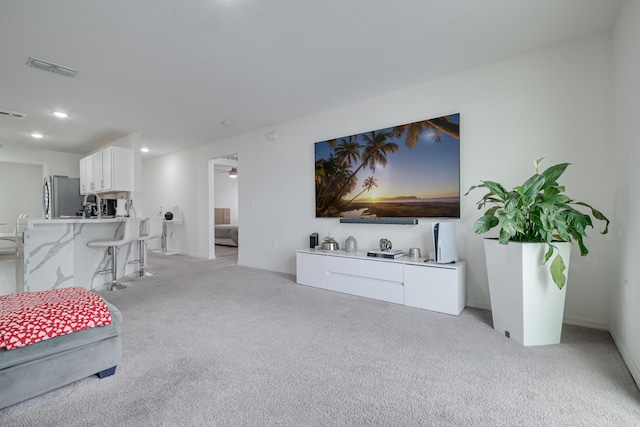 carpeted living room featuring ceiling fan