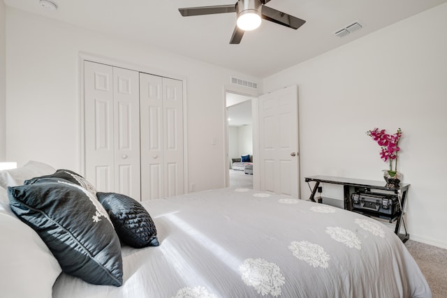 carpeted bedroom featuring ceiling fan and a closet