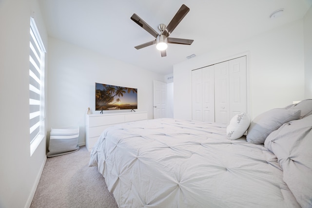 carpeted bedroom featuring ceiling fan and a closet