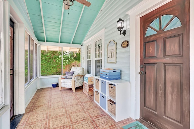 sunroom / solarium with ceiling fan, wood ceiling, and vaulted ceiling