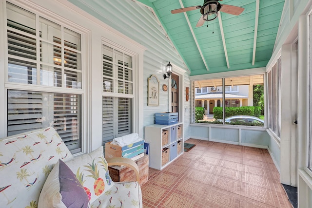 unfurnished sunroom with vaulted ceiling with beams, ceiling fan, and wood ceiling