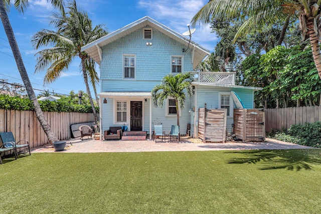 rear view of property featuring a yard and a patio