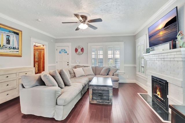 living room with a fireplace, ceiling fan, crown molding, and a textured ceiling