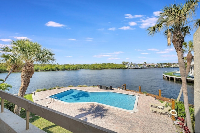 view of swimming pool with a patio and a water view