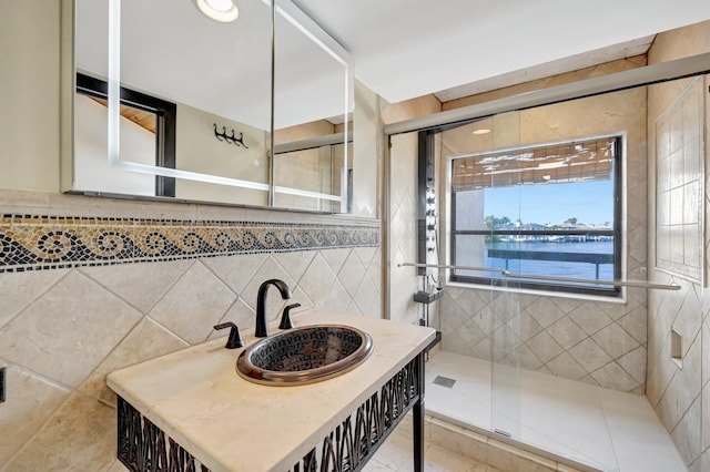 bathroom featuring tile walls, sink, walk in shower, and a water view