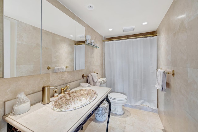 bathroom featuring toilet, tile walls, vanity, a shower with shower curtain, and tile patterned flooring