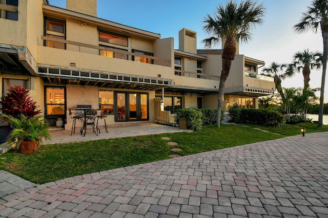 rear view of house with a patio area and a lawn