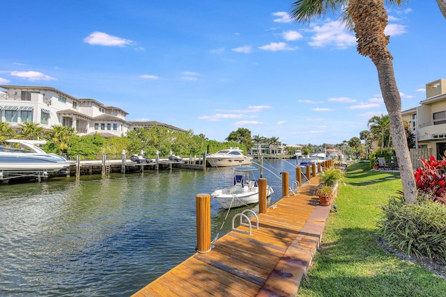 dock area with a water view and a yard