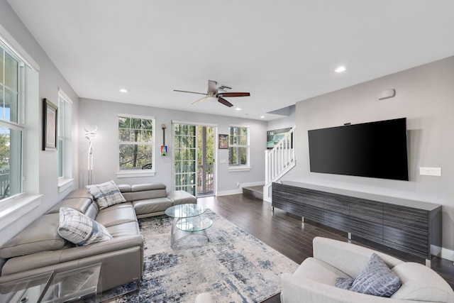 living room featuring ceiling fan and dark wood-type flooring