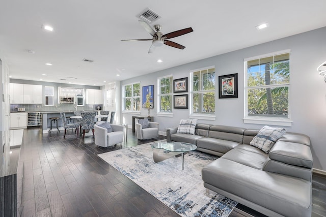 living room featuring a wealth of natural light, dark wood-type flooring, and ceiling fan