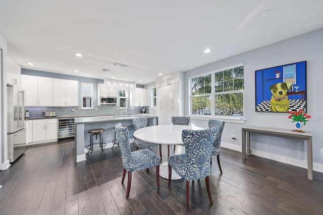 dining room with dark hardwood / wood-style floors, beverage cooler, and sink